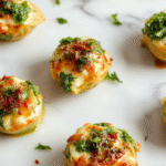 A vibrant plate of baked spinach and ricotta stuffed pasta shells arranged artfully on a white ceramic dish. The shells are golden brown with melted cheese and bright green spinach filling visible. Garnished with fresh herbs and served alongside a light salad with cherry tomatoes and a drizzle of olive oil, creating a colorful and inviting presentation.
